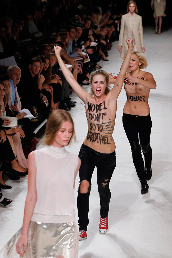 Activists of the feminist movement FEMEN protest on the catwalk as models present creations for Nina Ricci during the 2014 Spring/Summer ready-to-wear collection fashion show, on September 26, 2013 in Paris.  AFP PHOTO / JOEL SAGET        (Photo credit should read JOEL SAGET/AFP/Getty Images)